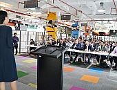 DTEC Alibaba Conquest How to be happy A woman presents on stage in front of a jury seated at a table during the Alibaba Cloud Startup Contest at DTEC
